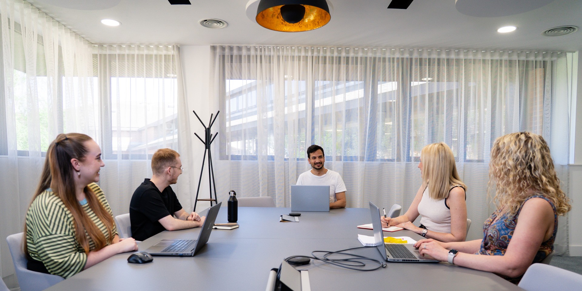 A Crafted team working around a desk in the office.