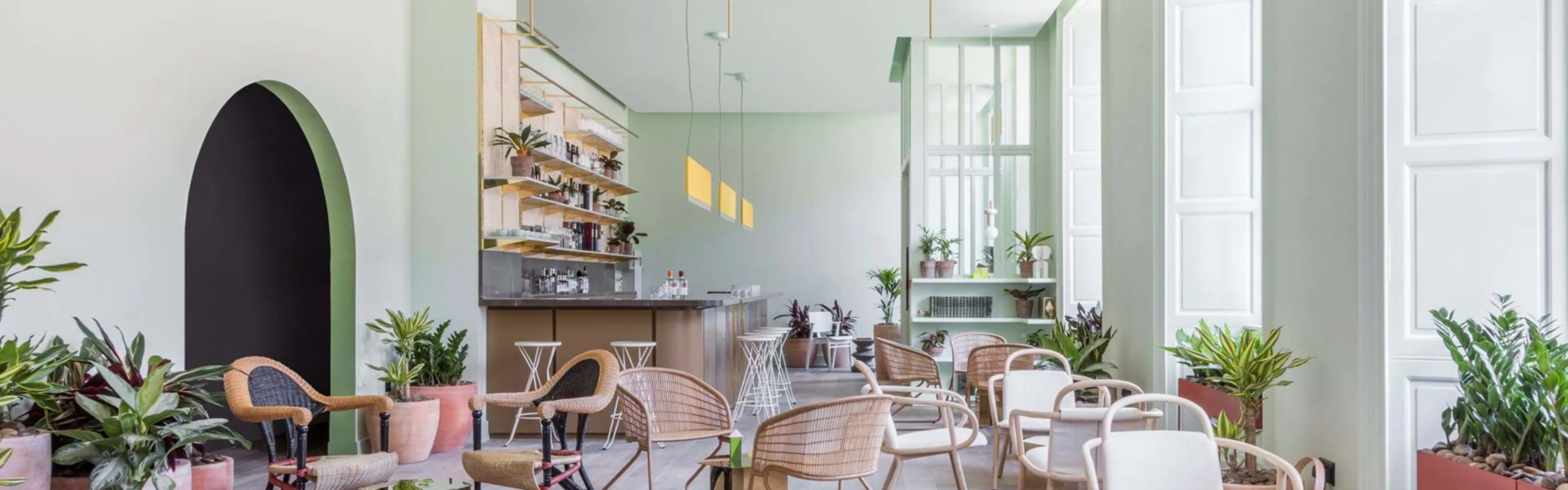 a light open space  in an aparthotel with lots of seating and a bar 