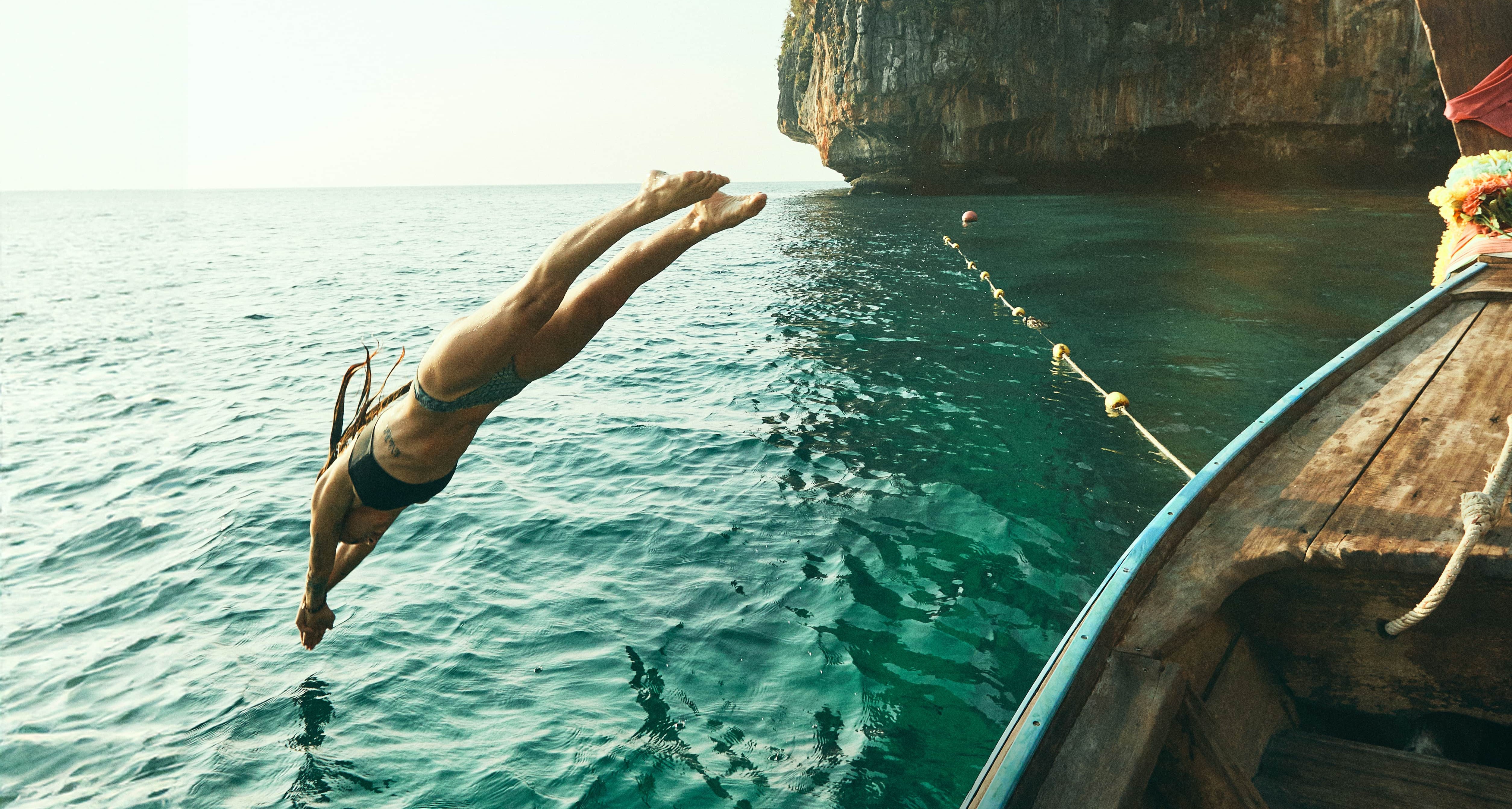 A person diving into the sea in a warm coastal location