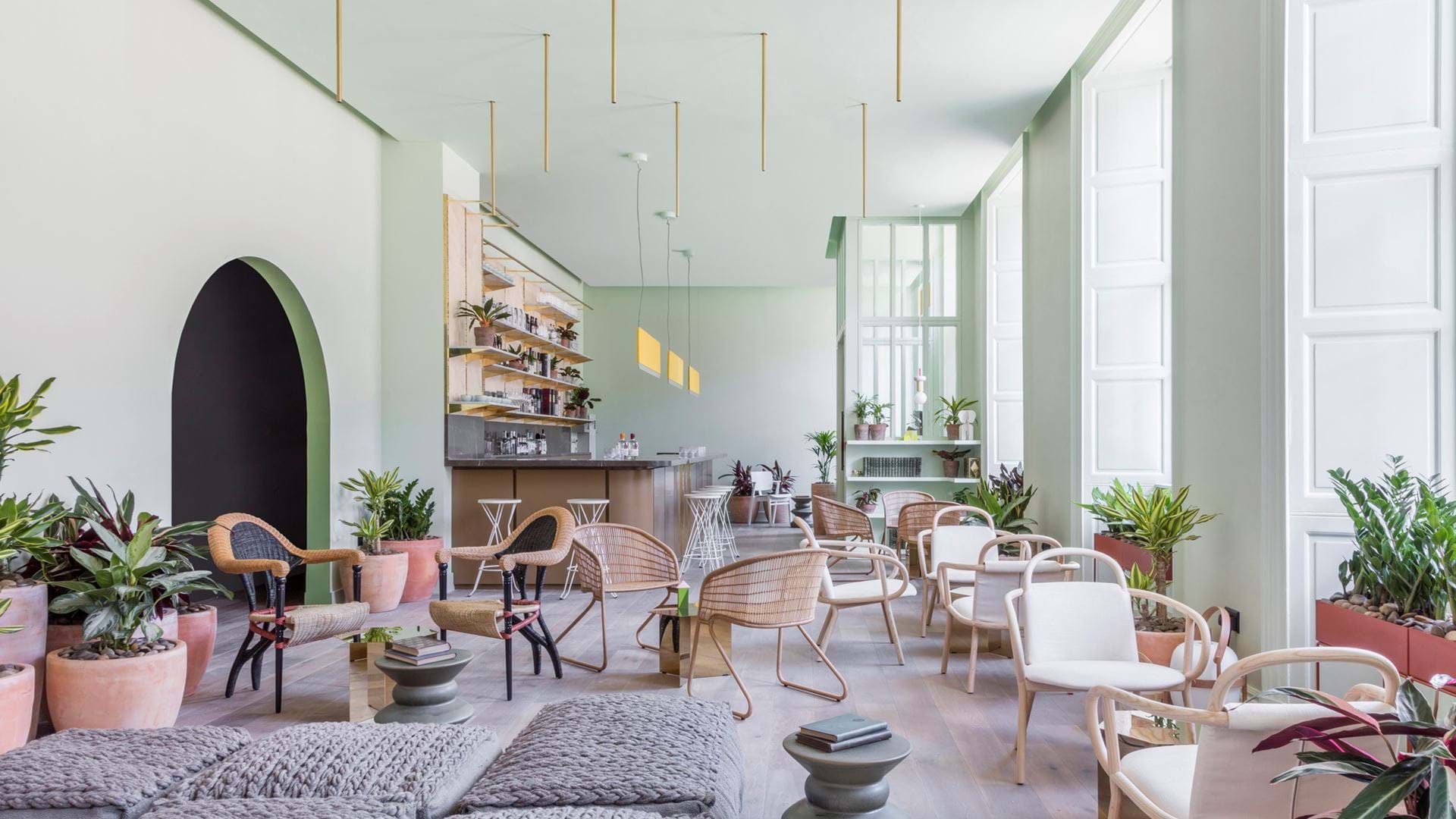 a light open space  in an aparthotel with lots of seating and a bar 
