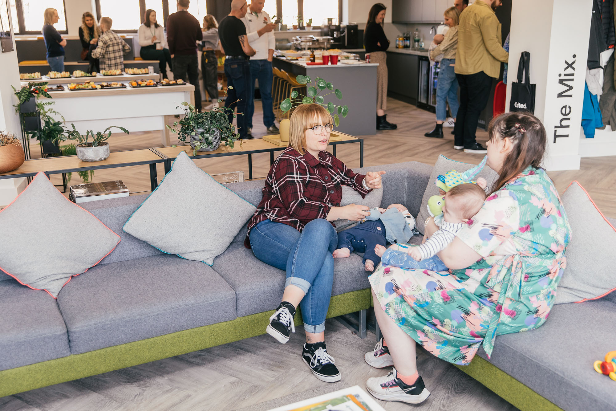 Two Crafted team members with their babies on the sofa in the Crafted office.