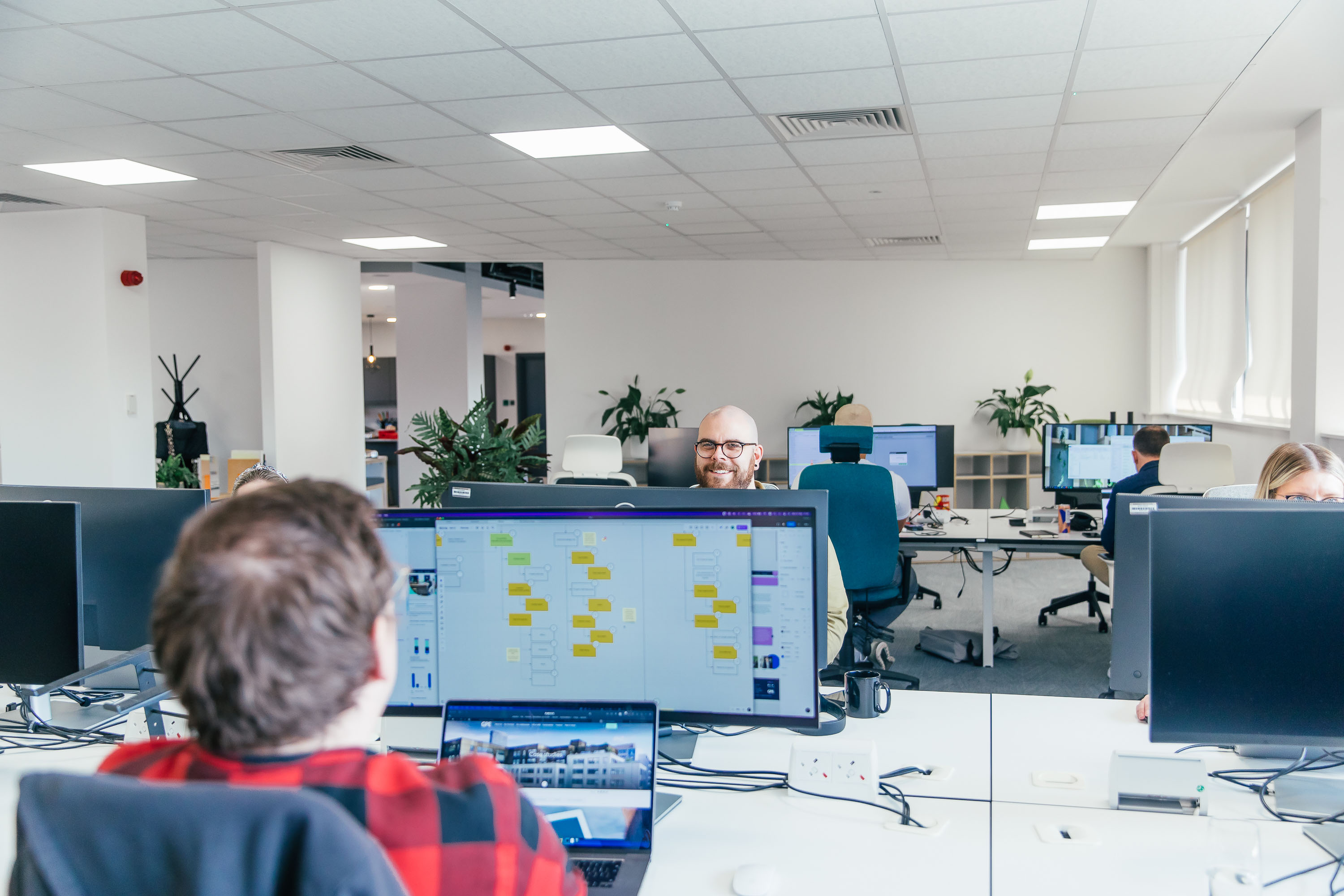 Crafted team members laughing to each other across the desk