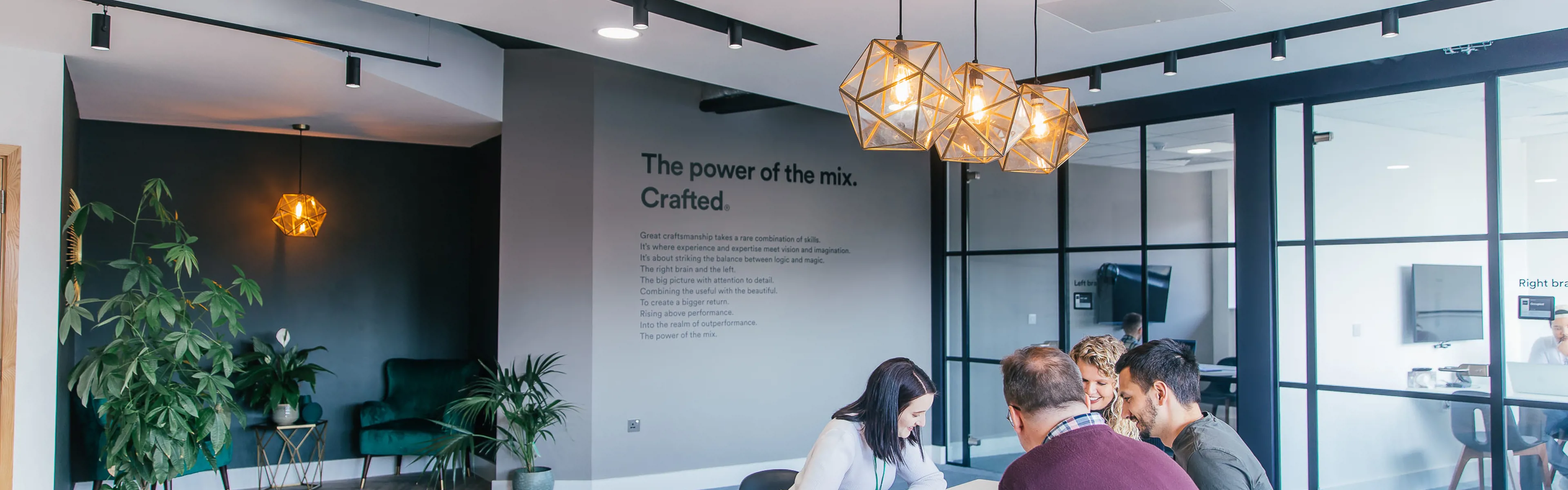 A Crafted team working around a desk in the office.
